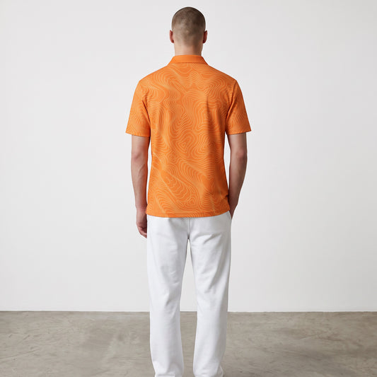 BREAKPOINT Sportswear orange performance golf polo with topographic line pattern, back view on a male model.