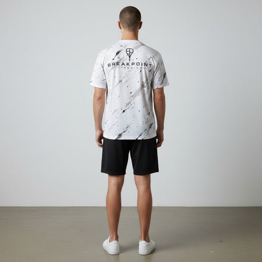 BREAKPOINT Sportswear white tennis t-shirt with black splatter print and logo on the back, worn by a male athlete.