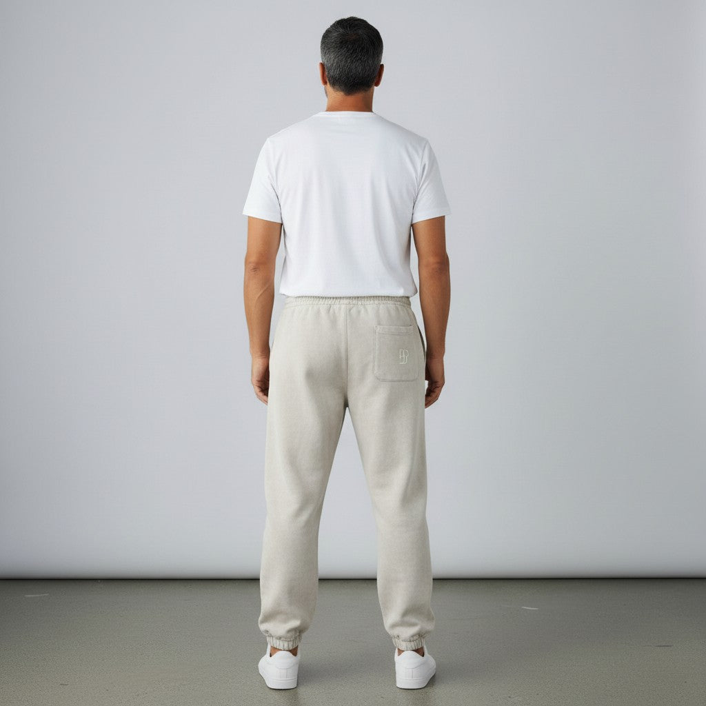 Rear view of a man wearing BREAKPOINT Sportswear beige fleece sweatpants with a back pocket and cuffed ankles.