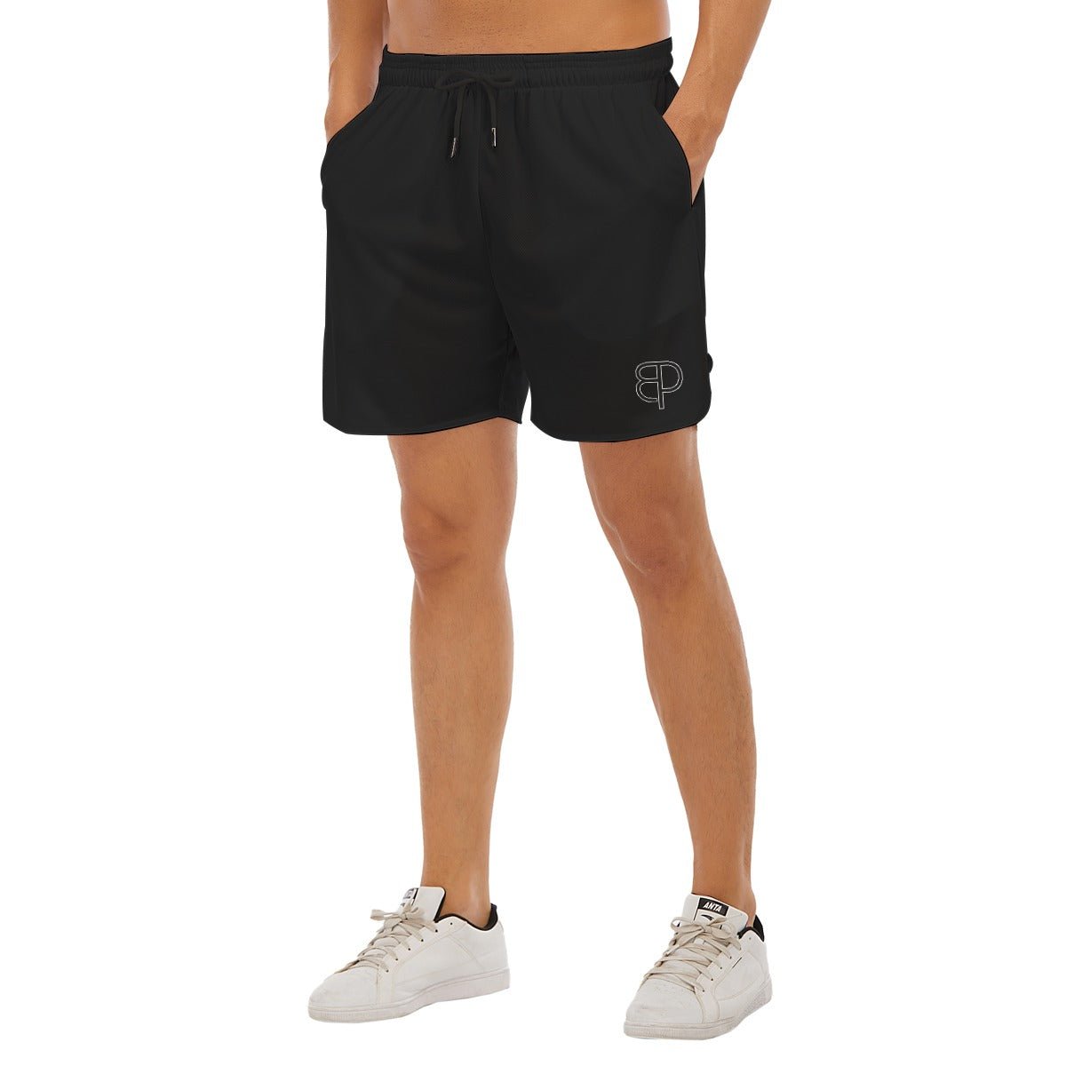 BREAKPOINT Sportswear black athletic shorts with side-split hem and white logo on a model wearing white sneakers.