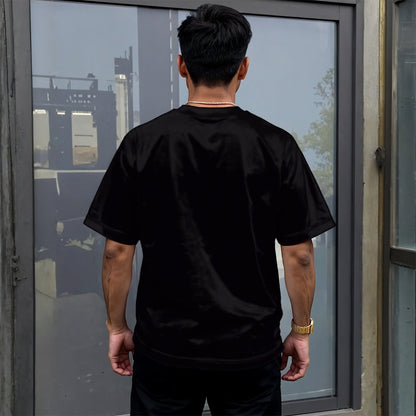 BREAKPOINT Sportswear unisex black drop-shoulder t-shirt with relaxed fit worn by a man from the back view.