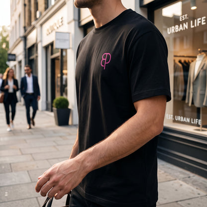 BREAKPOINT Sportswear black unisex drop-shoulder t-shirt with pink logo on chest, worn by a man on a city street.