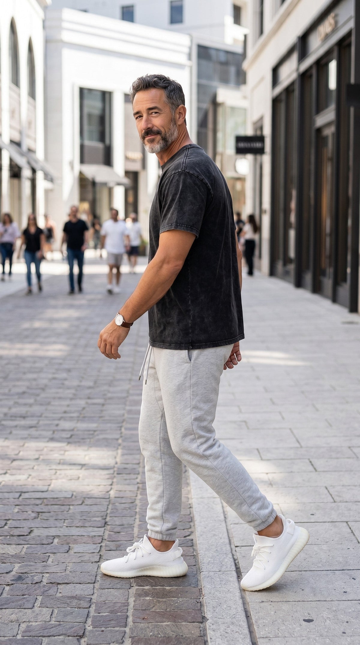 BREAKPOINT Sportswear unisex black snow wash cotton t-shirt with drop shoulder fit worn by a man on a city street.