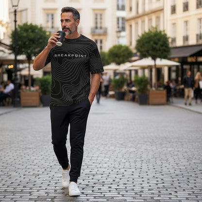 BREAKPOINT Sportswear black drop-shoulder tee with white topographic line print worn by a man walking outdoors