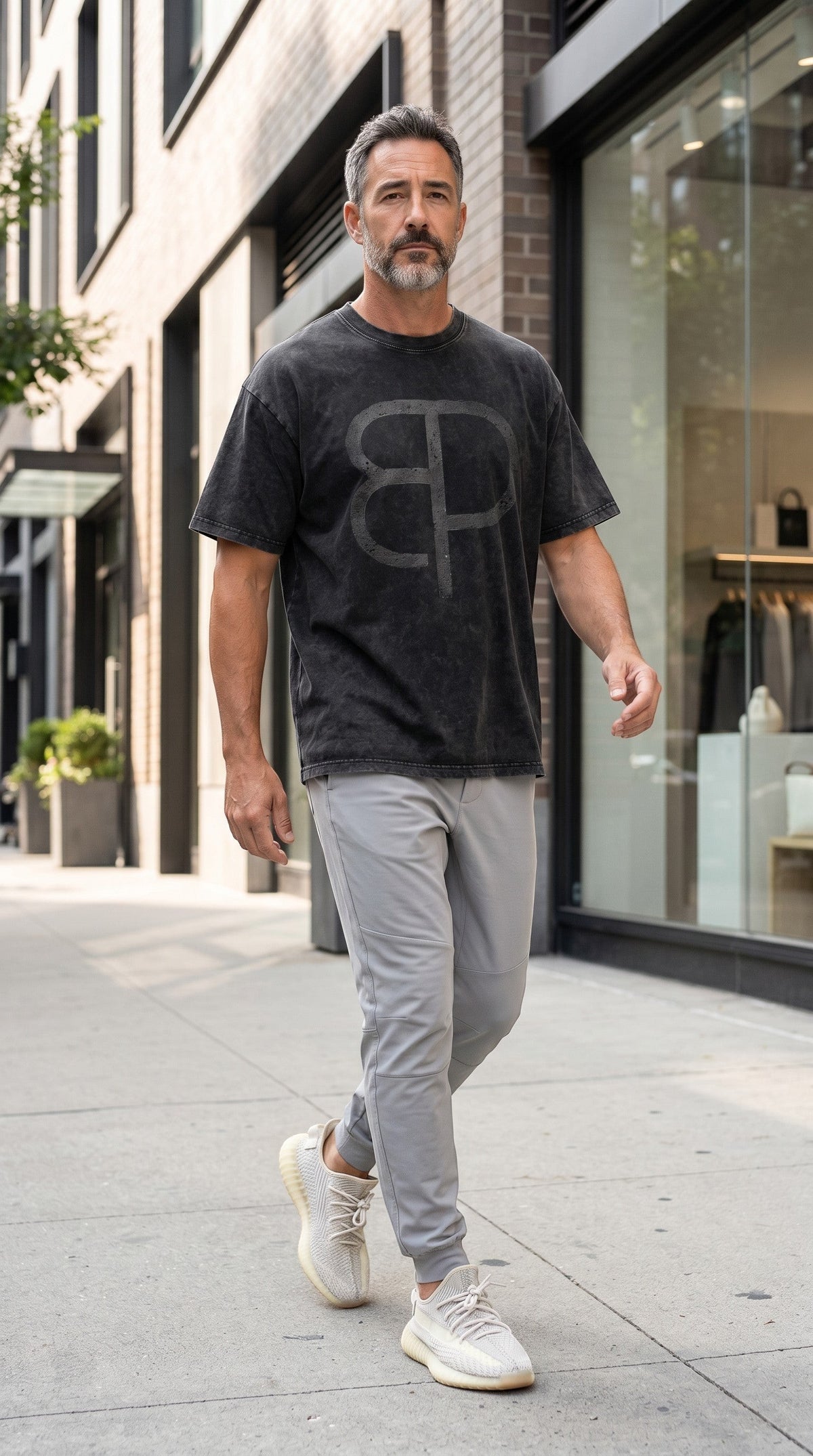 A man wearing a BREAKPOINT Sportswear black snow-washed cotton t-shirt with a drop shoulder and BP logo print.