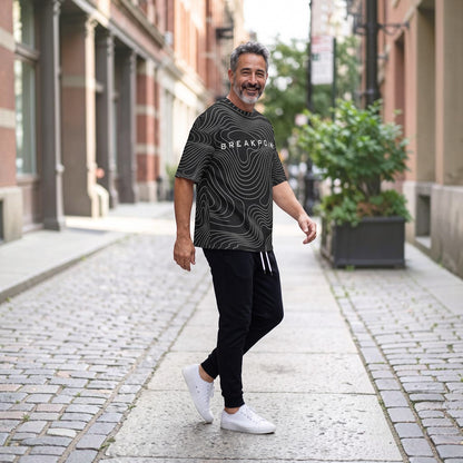BREAKPOINT Sportswear black and white drop-shoulder tee with topographic print worn by a man on a city street.