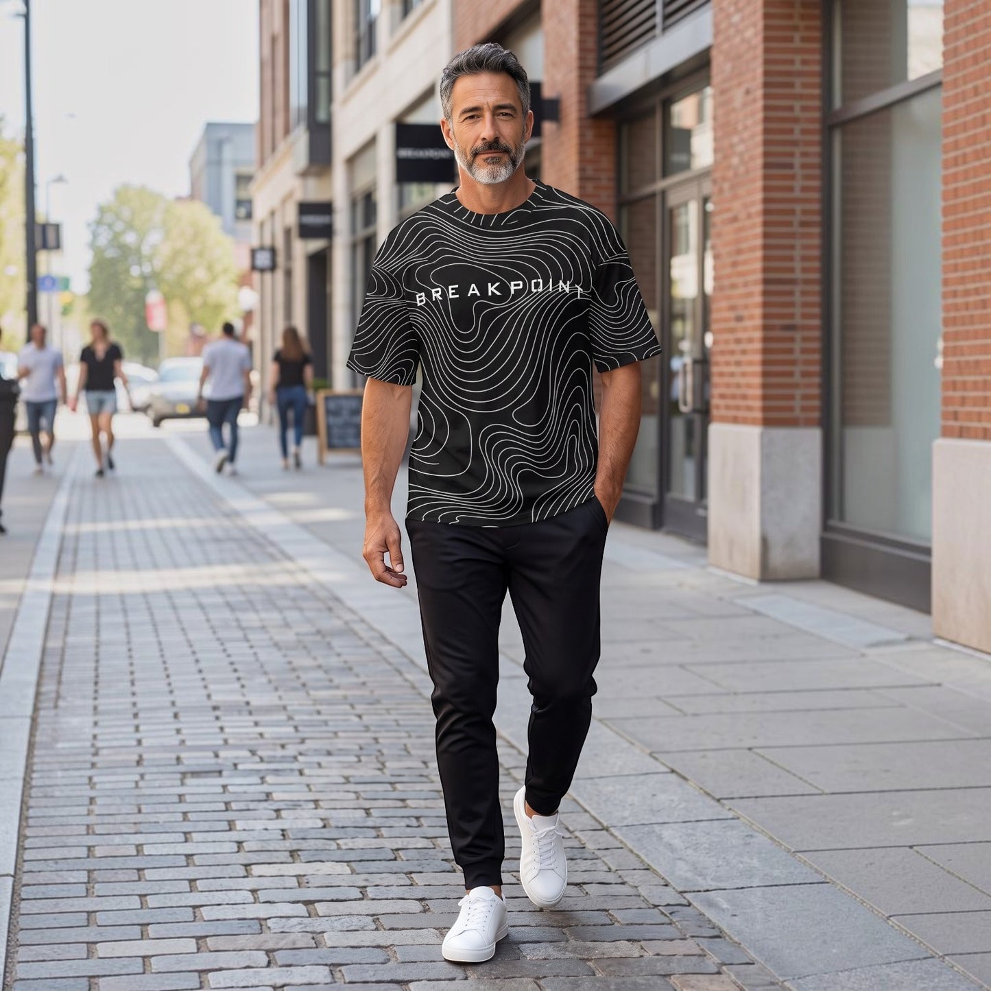 BREAKPOINT Sportswear black and white drop-shoulder tee with topographic print worn by a man on a city street.