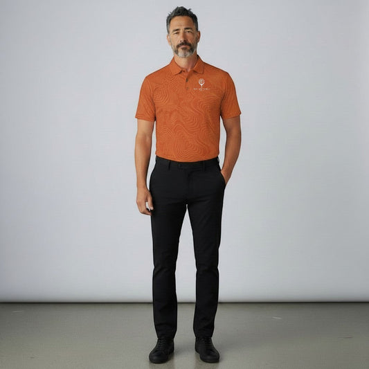 BREAKPOINT Sportswear burnt orange performance golf polo with topographic pattern, worn by a man with black trousers.