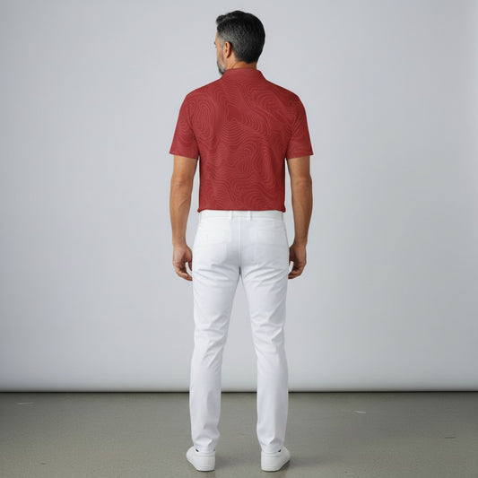 BREAKPOINT Sportswear crimson performance polo shirt with topographic pattern worn by a man with white golf trousers