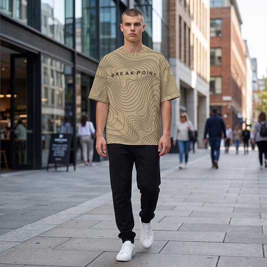 BREAKPOINT Sportswear gold and black drop-shoulder tee with topographic print worn by a man on a city street.