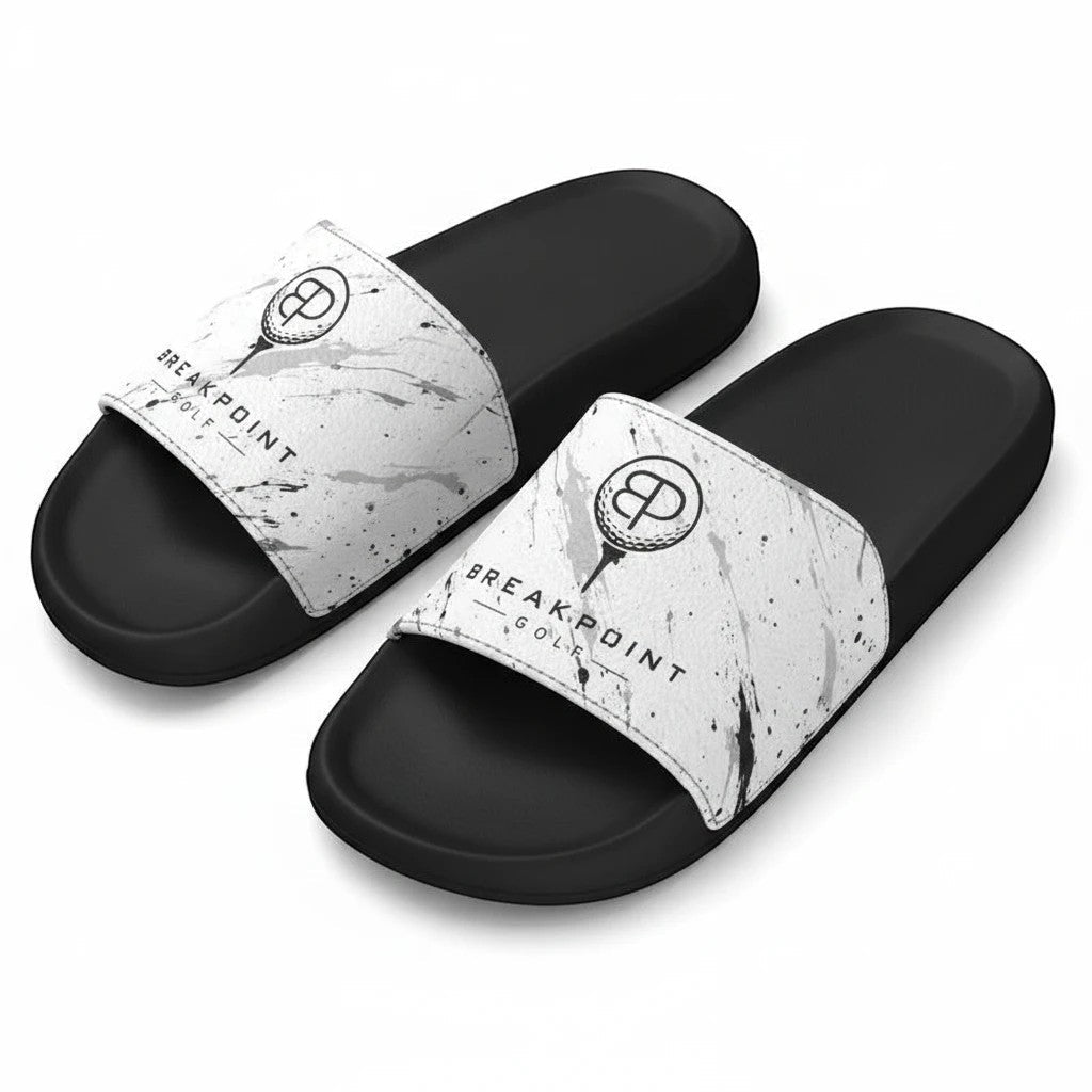 BREAKPOINT Sportswear slides featuring white straps with black paint splatter design.