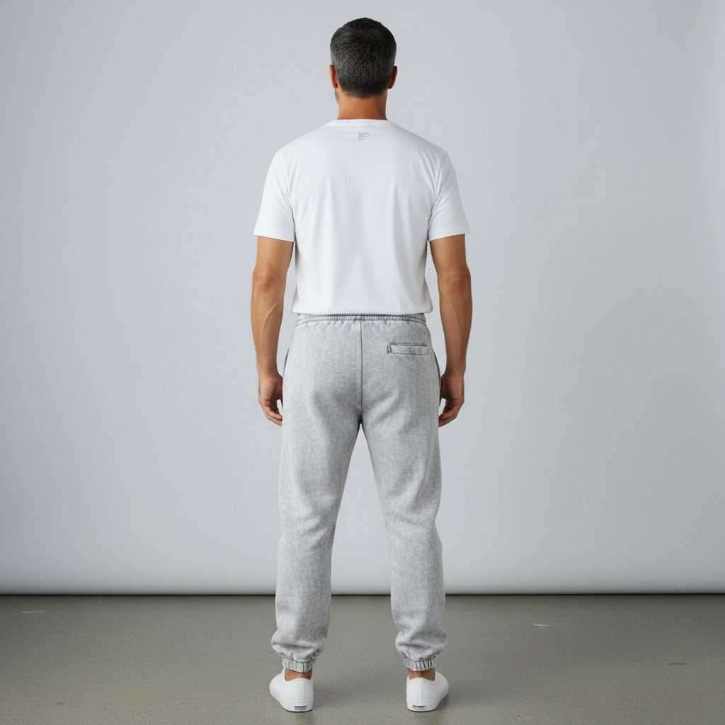 Rear view of a man wearing BREAKPOINT Sportswear grey fleece sweatpants and a white t-shirt against a plain background.