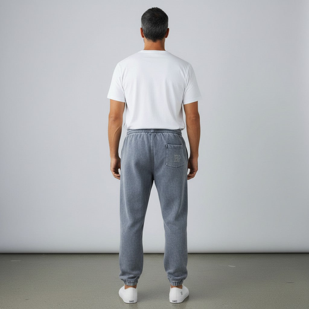 Rear view of a man wearing BREAKPOINT Sportswear grey fleece sweatpants with a back pocket and cuffed ankles.