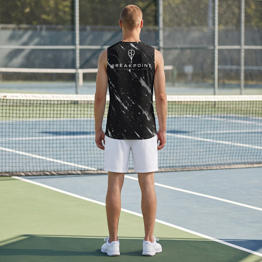 A man wearing a BREAKPOINT Sportswear black and white patterned tank top with white shorts on a tennis court.