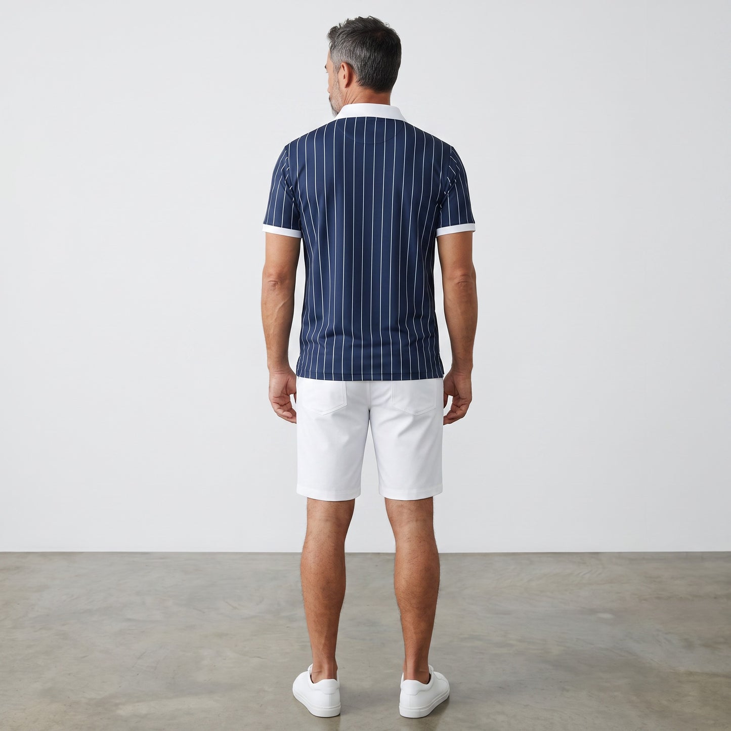 Rear view of a man wearing a BREAKPOINT Sportswear navy blue pinstripe polo shirt with white collar and trim.