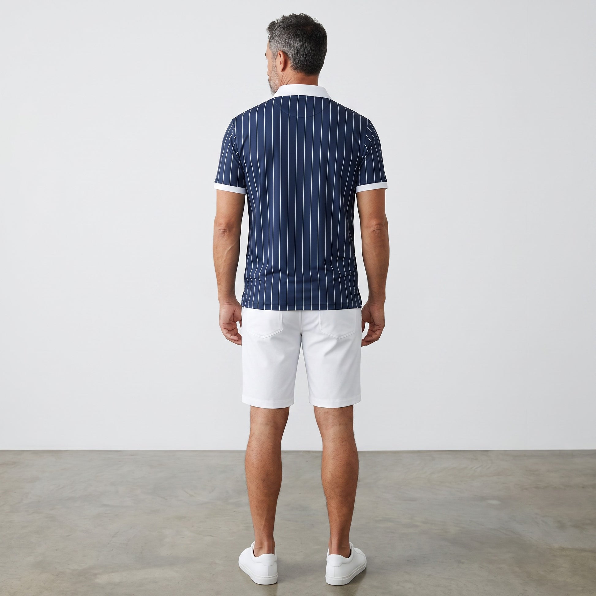 Rear view of a man wearing a BREAKPOINT Sportswear navy blue pinstripe polo shirt with white collar and trim.