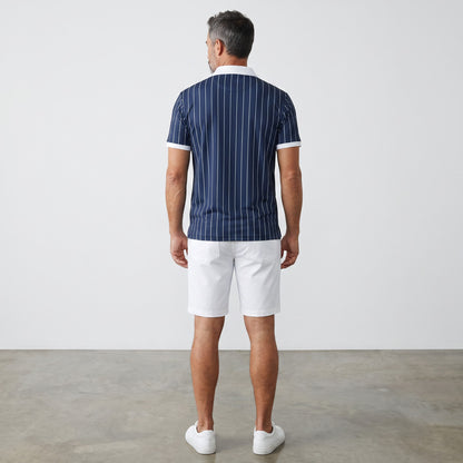 Rear view of a man wearing a BREAKPOINT Sportswear navy blue pinstripe polo shirt with white collar and trim.