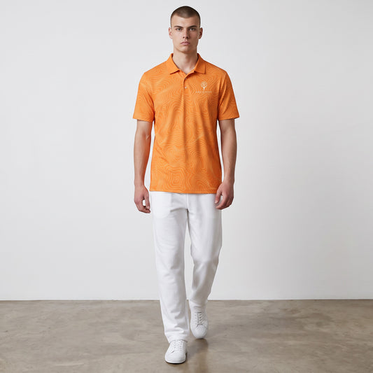 BREAKPOINT Sportswear orange performance golf polo with topographic print, three-button collar, and white trousers.