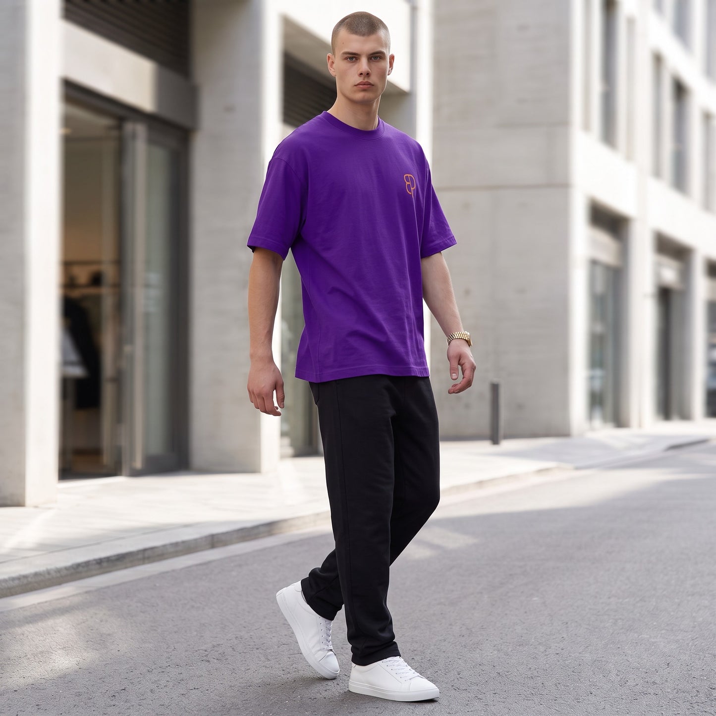 BREAKPOINT Sportswear purple drop-shoulder t-shirt with orange logo on a model walking on a city street.