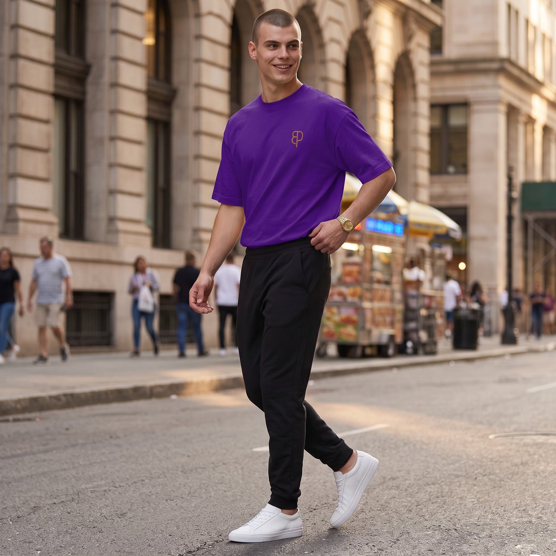 BREAKPOINT Sportswear purple drop-shoulder t-shirt with logo on a man walking on a city street.