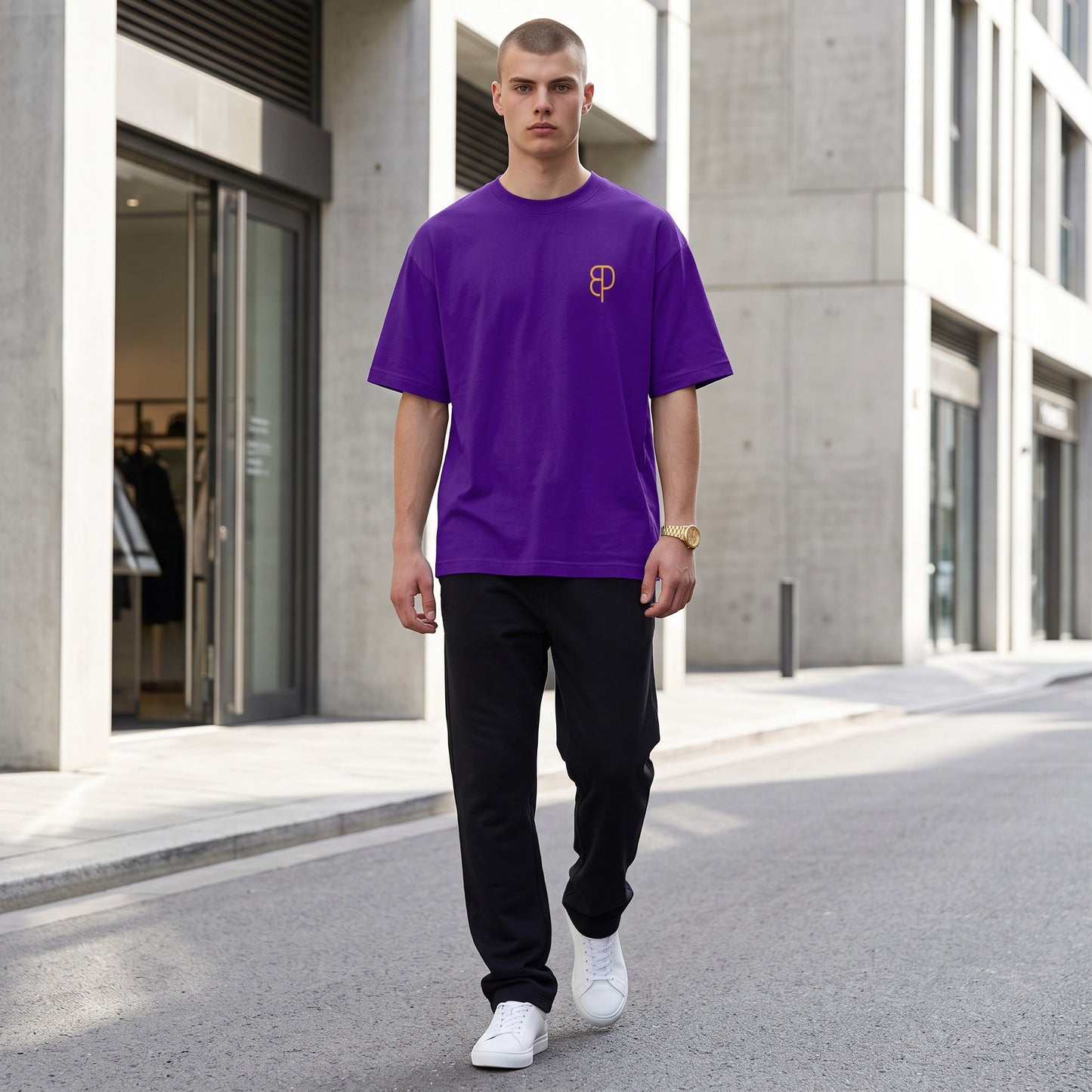 BREAKPOINT Sportswear unisex purple drop-shoulder t-shirt with gold logo, worn by a man on a city street.