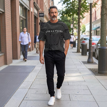 BREAKPOINT Sportswear black and white topographic print drop-shoulder tee worn by a man on a city street.
