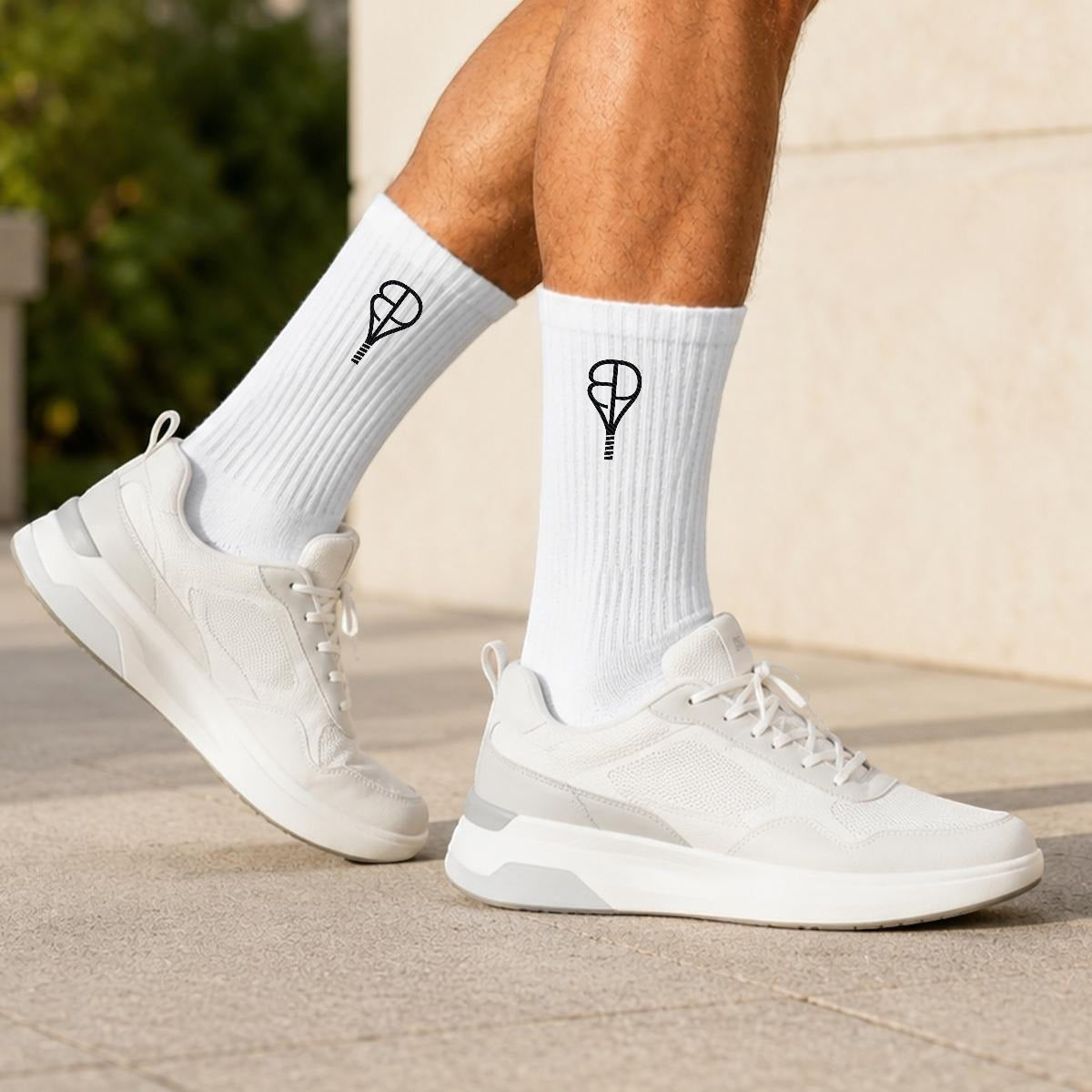 BREAKPOINT Sportswear white cotton crew socks with black embroidered logo worn with white athletic sneakers