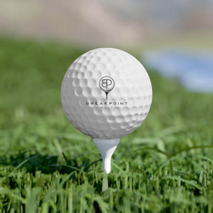 BREAKPOINT Sportswear white golf ball with black logo on a white tee in green grass