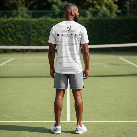 BREAKPOINT Sportswear white performance tee with static print worn by a man on a tennis court from the back view.