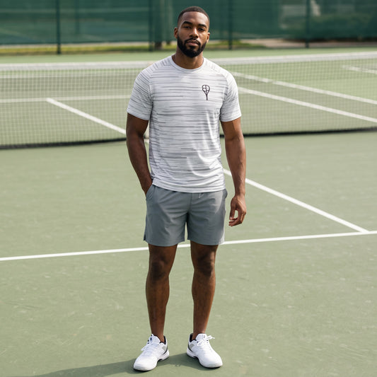 BREAKPOINT Sportswear white performance tee with grey static print worn by a man on a tennis court.