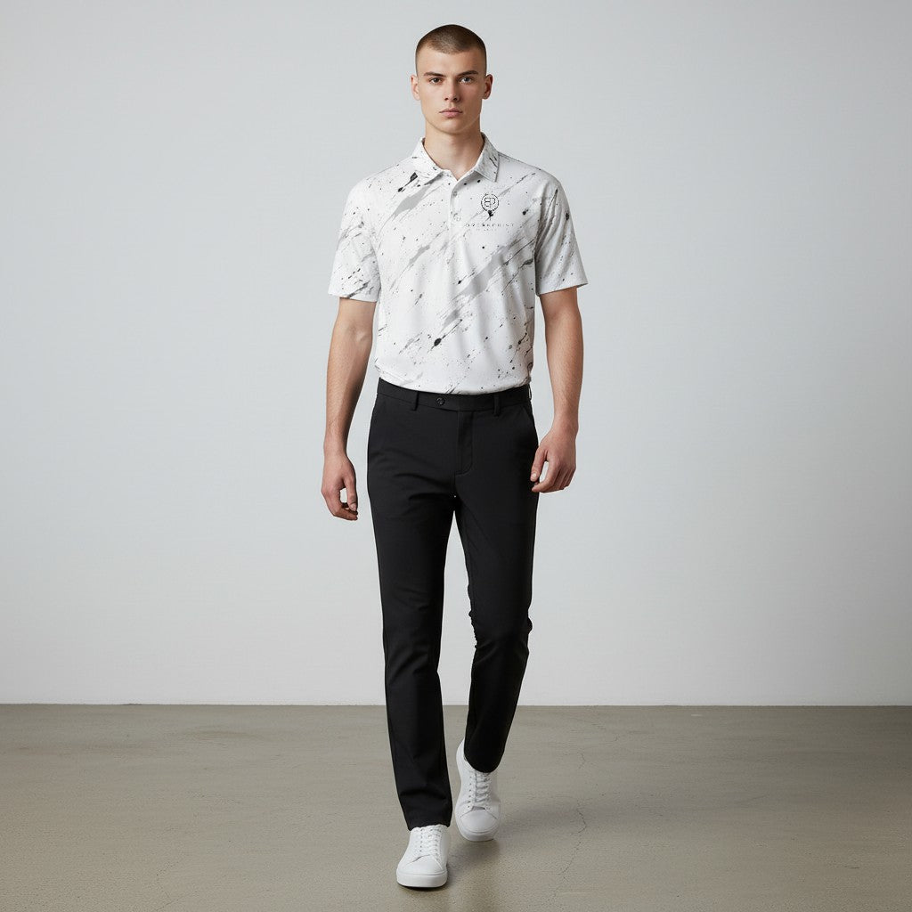 BREAKPOINT Sportswear white performance polo with black splatter print, worn by a man with black trousers and sneakers.