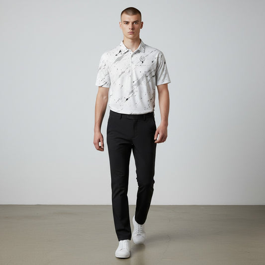 BREAKPOINT Sportswear white performance polo with black splatter print, worn by a man with black trousers and sneakers.