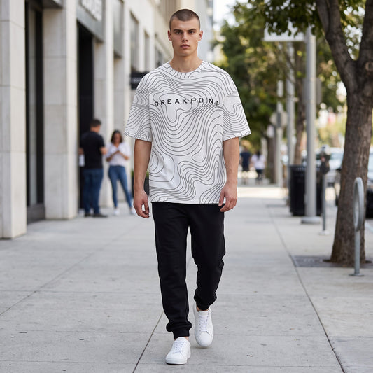 BREAKPOINT Sportswear white drop-shoulder tee with black topographic line print worn by a man on a city sidewalk.
